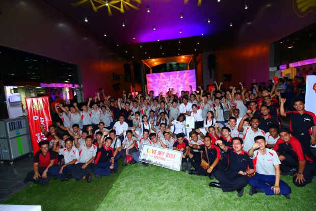 The Shell Malaysia team celebrating with the mechanics from Despark College who worked hard to complete 378 engine oil changes for a new Malaysia Book of Records entry